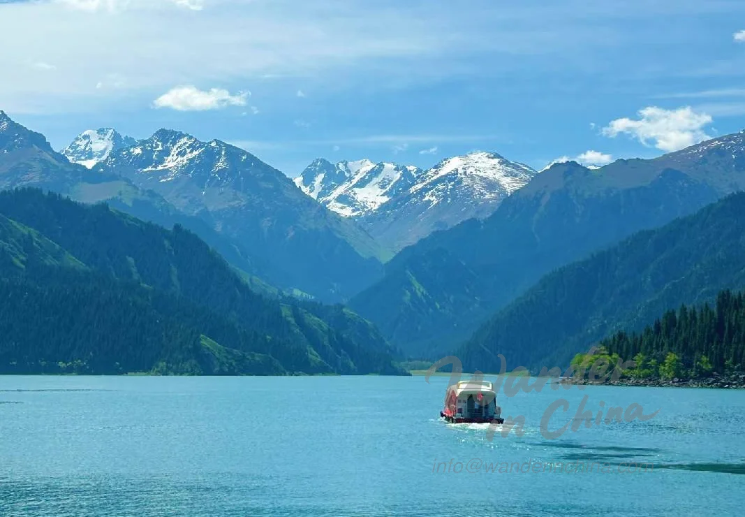 天山天池上的船只,有山脉倒影。