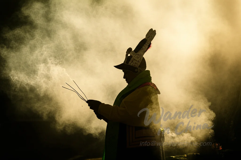 Dongba-Schamane führt ein Ritual durch.