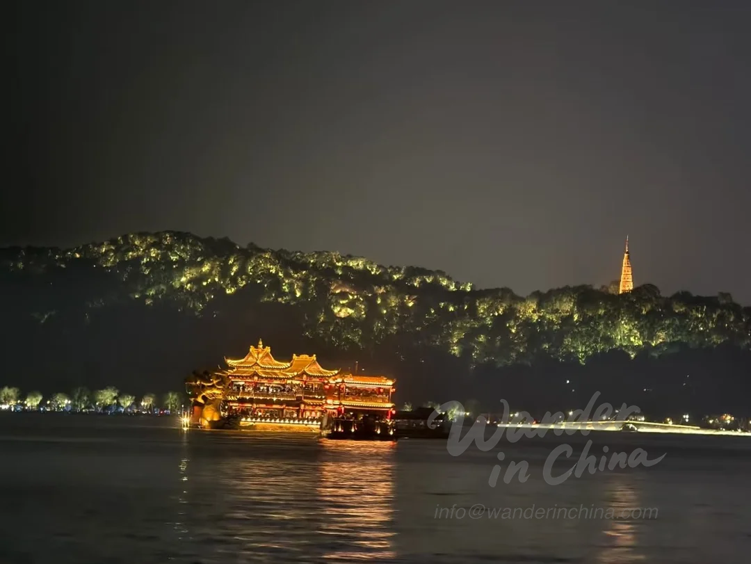 West Lake night cruise with city lights reflection.